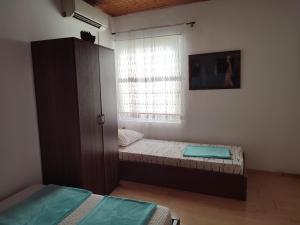 um quarto com duas camas e um armário e uma janela em Apartment Mejdan em Mostar