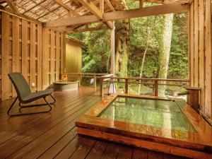 a screened in porch with a chair on a wooden floor at Mizumari in Kawazu