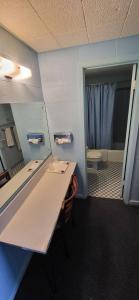 y baño con lavabo, aseo y espejo. en Holiday Host Motel & RV Park, en Sonora