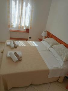 a bedroom with a large bed with two towels on it at Il rifugio dello scultore in Niscemi