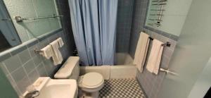 y baño con aseo, lavabo y ducha. en Holiday Host Motel & RV Park, en Sonora