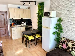 a kitchen with a white refrigerator and a table with chairs at Budget First Sea Line Apt. FLORA in Pomorie