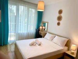 a bedroom with a bed with towels on it at First Sea Line Apartment FLORA, next to the beach in Pomorie +86 photos