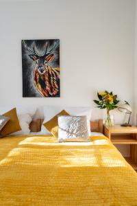 a bedroom with a yellow bed with a painting on the wall at Dom Krawca - pod Chojnikiem in Jelenia Góra