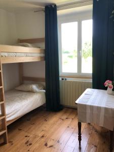 a bedroom with two bunk beds and a table at Maison d'hôtes Larraldia in Uhart-Cize