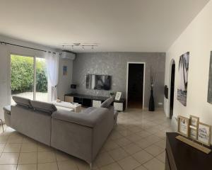 a living room with a couch and a tv at Maison à biscarrosse avec piscine et jacuzzi in Biscarrosse