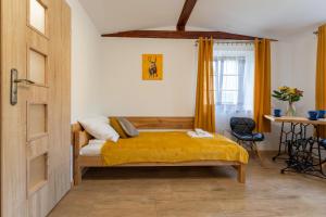 a bedroom with a bed with a yellow blanket at Dom Krawca - pod Chojnikiem in Jelenia Góra