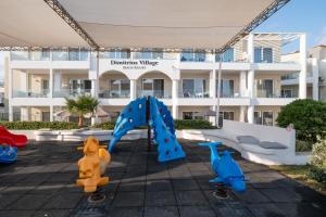 a playground in front of a apartment building at Dimitrios Village Beach Resort in Rethymno Town