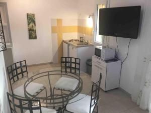 a room with a table and chairs and a television at « Chez Nath et Chris » in Saint-André-de-Cubzac