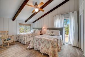 a bedroom with two beds and a ceiling fan at Perched Above the River in Lago Vista