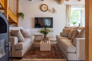 a living room with two couches and a clock on the wall at Landhaus einer Malerin in Poseritz