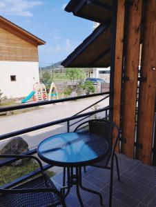 a table and chairs on a balcony with a playground at Villa Megobrebi in Bakuriani
