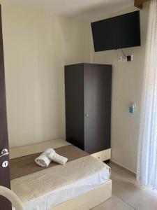 a bedroom with a bed with a black cabinet at VILLA HARIKLIA in Paralia Katerinis