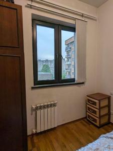 エレバンにあるCosy and quiet home in Yerevan!のベッドルーム1室(窓、ドレッサー、ベッド1台付)