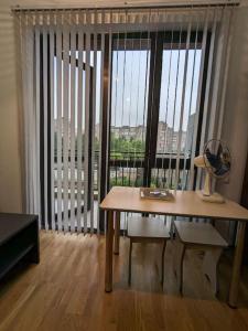 エレバンにあるCosy and quiet home in Yerevan!の扇風機と大きな窓のあるテーブルのある部屋