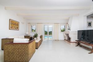 salon z kominkiem i telewizorem w obiekcie Villa Verdi - Your Family Oasis! w mieście Vasilikos