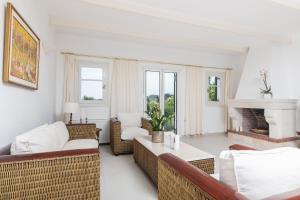 salon z wiklinowymi meblami i kominkiem w obiekcie Villa Verdi - Your Family Oasis! w mieście Vasilikos +30 zdjęć