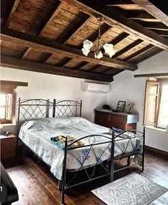 BaradiliDomus de Jara - Casa Usai的一间带金属床的卧室,位于带木制天花板的客房内。