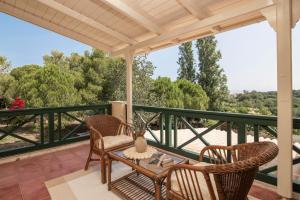 patio con mesa y sillas en el balcón en Villa Verdi - Your Family Oasis!, en Vasilikos