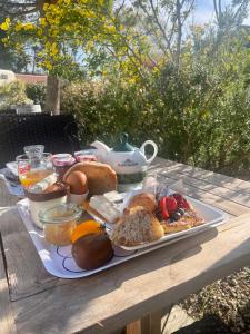 - un plateau de petit-déjeuner sur une table en bois dans l'établissement La Villa - Hôtel Bien Être, au Bois-Plage-en-Ré