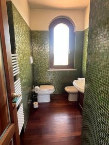 een badkamer met 2 toiletten, een wastafel en een raam bij Villa Emma in Torrevecchia Teatina