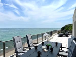 Апартамент Бийч Вю Обзор - Apartment Beach View Obzor في ابزور: طاولة وكراسي على شرفة مطلة على المحيط