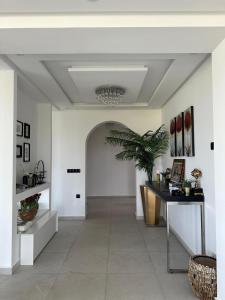 un corridoio con pareti bianche, tavolo e pianta di Villa Marina Hills - Tamuda Bay a Jebel Zemzem