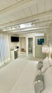 una grande camera bianca con un letto e una cucina di Moustakas Beach Apartments ad Adámas