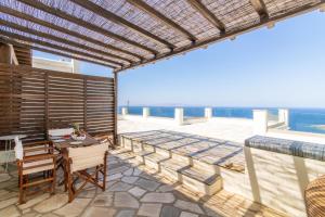a patio with a table and chairs and the ocean at ReGenesis Villas in Kardhianí