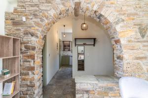 a hallway with an archway in a stone wall at ReGenesis Villas in Kardhianí
