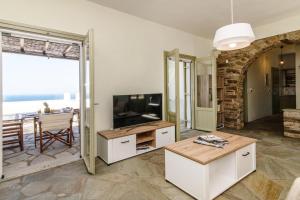 a living room with a television and a table at ReGenesis Villas in Kardhianí