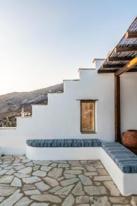 a white house with stairs and blue cushions at ReGenesis Villas in Kardhianí