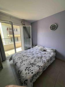 a bedroom with a bed and a clock on the wall at Beautiful flat with sunny balcony in heart of Nice Le Port in Nice
