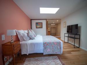 a bedroom with a bed and a flat screen tv at Clos des Oliviers in Mirepoix
