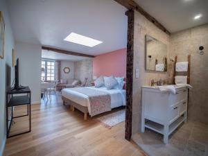 a bedroom with a large bed and a bathroom at Clos des Oliviers in Mirepoix
