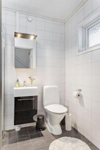 a white bathroom with a toilet and a sink at Spacious 6-bedroom villa! in Boden