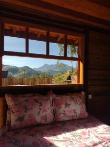 a bed in a room with a window with a view at Chale brilho do sol in Visconde De Maua