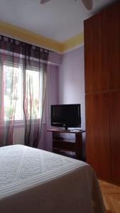 a bedroom with a bed and a flat screen tv at appartamento incantevole a Ospedaletti(Sanremo) in Ospedaletti