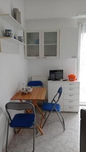 a kitchen with a wooden table and blue chairs at appartamento incantevole a Ospedaletti(Sanremo) in Ospedaletti