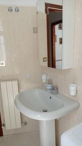 La salle de bains est pourvue d'un lavabo blanc et d'un miroir. dans l'établissement appartamento incantevole a Ospedaletti(Sanremo), à Ospedaletti