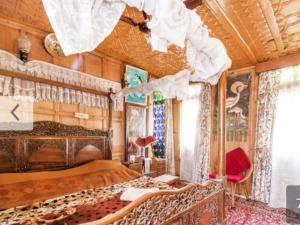 een slaapkamer met een groot bed en een houten plafond bij New Minar Group Of houseboats in Srinagar