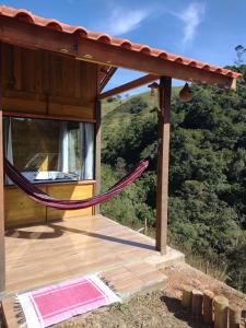a hammock on the deck of a house at Chale brilho do sol in Visconde De Maua