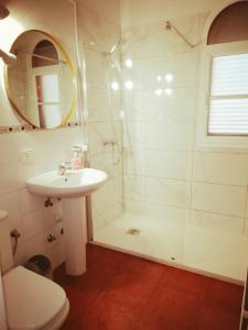 ein weißes Bad mit einer Dusche und einem Waschbecken in der Unterkunft Casa Buganvilla in Los Realejos
