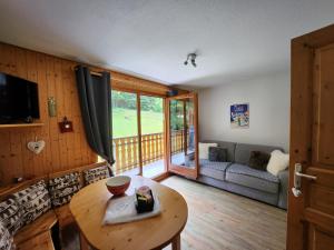 sala de estar con mesa y sofá en Cocon à chatel, en Châtel