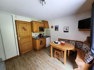 a small kitchen with a wooden table and a small dining room at Cocon à chatel in Châtel