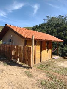 a small house with a fence in front of it at Chale brilho do sol in Visconde De Maua