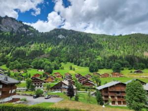 a village in the mountains with houses and trees at Cocon à chatel in Châtel