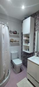 La salle de bains est pourvue de toilettes blanches et d'un lavabo. dans l'établissement Chambre haut standing, à Rabat