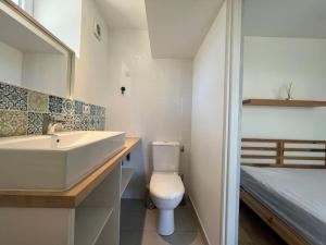 a bathroom with a sink and a toilet and a bed at La terrasse des Thermes, Jura in Lons-le-Saunier