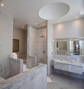a bathroom with a shower and a tub and a sink at The Chatsworth Hotel in Eastbourne